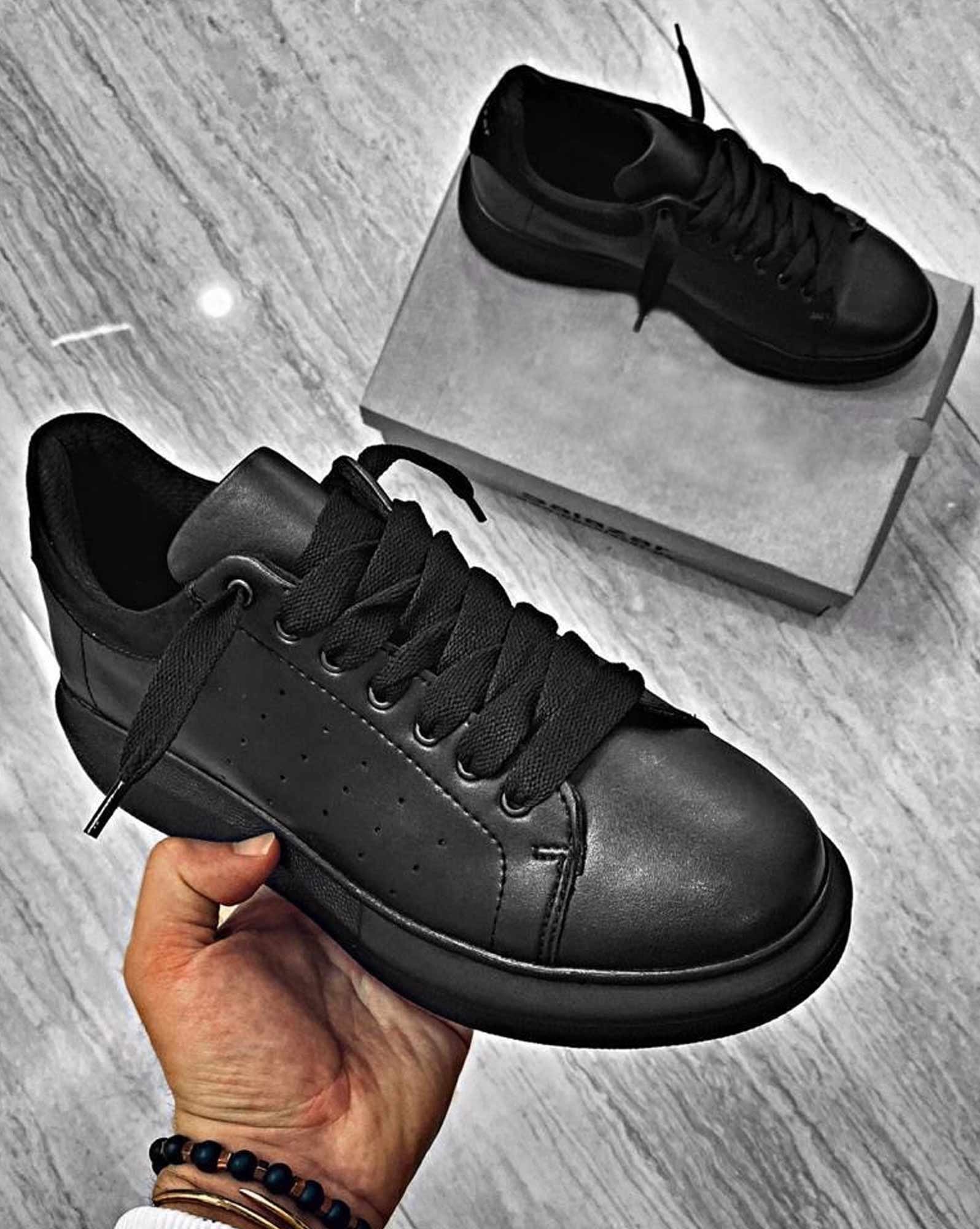 Pair of black sneakers with black rubber sole