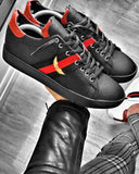 Zapatillas deportivas negras con bandas laterales en las ruedas y logo de alas bordado