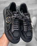 Chaussures Sneakers noir tendance à lacets avec écriture blanches et badge métal et semelle noire pour homme