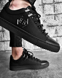 Zapatillas deportivas negras de moda con logo de metal y suela negra con muescas para hombre.