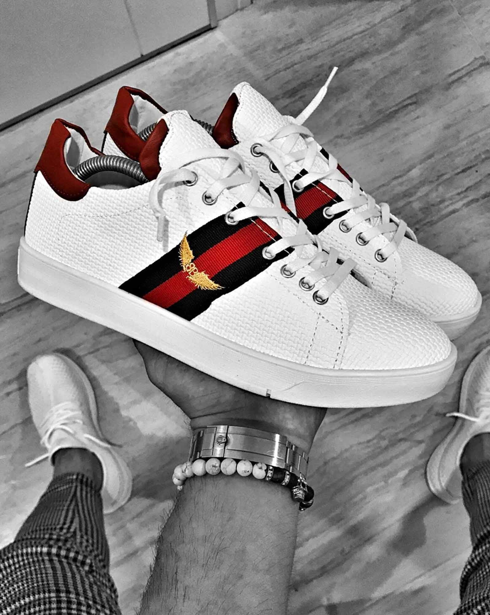 White sneakers with side bands and embroidered wings logo