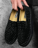 Zapatos con tachuelas tipo mocasines elásticos negros con aspecto de ante negro y tachuelas.